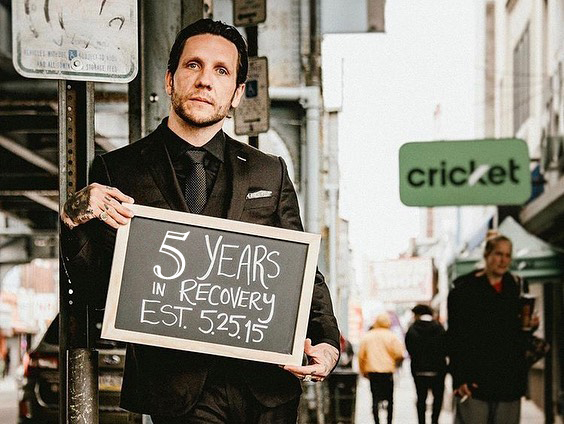 Brandon Novak holding up a sign that says 5 years in recovery