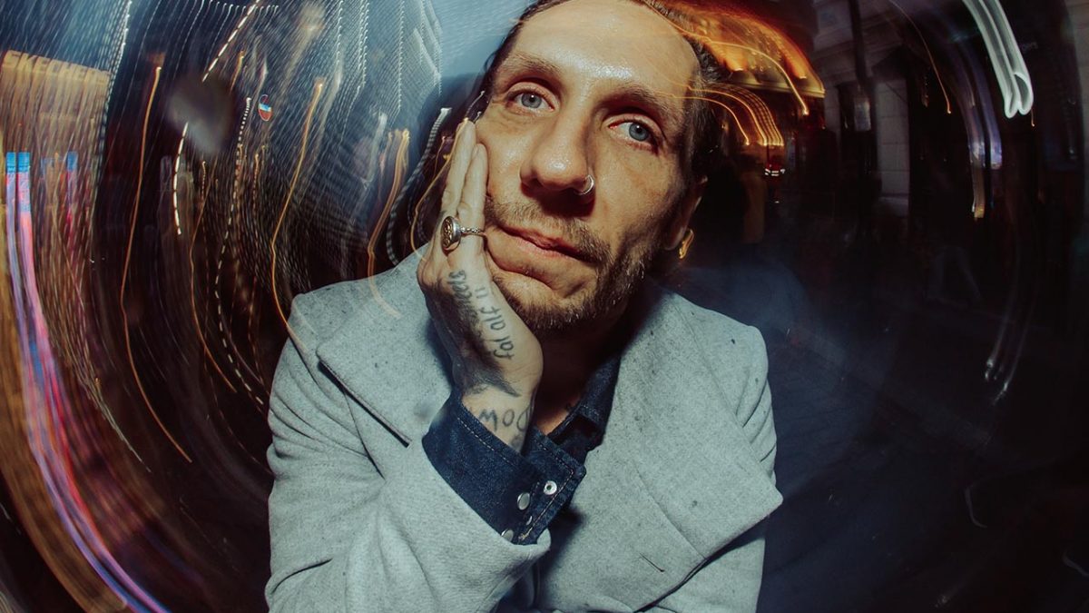 Brandon Novak with a grey coat and a pinky ring